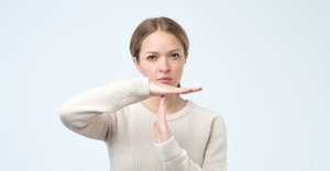 Closeup portrait of young woman showing time out gesture with hands isolated on gray wall background. Negative human emotion facial expressions, feeling body language reaction, attitude