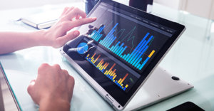 Close-up Of Businessperson Pointing At Graph On Digital Laptop In Office