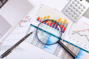 Image Of A Workplace With Papers and a magnifying glass