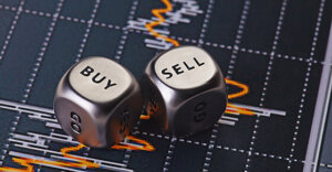 silver dice on a chart. The first die reads "buy" and the second reads "sell"