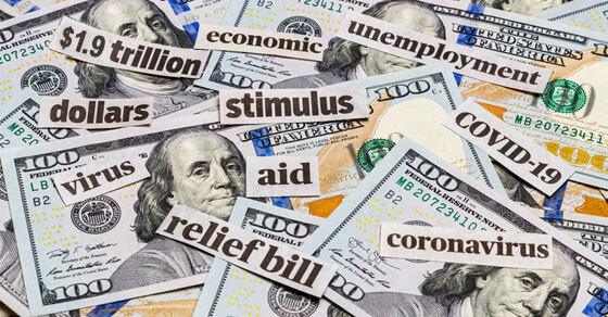 image of money on a table and words cut out of paper, placed on top of the month. Words include "stimulus", "relief bill", "economic", "unemployment"