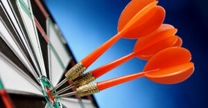 dart board with three darts on the bullseye