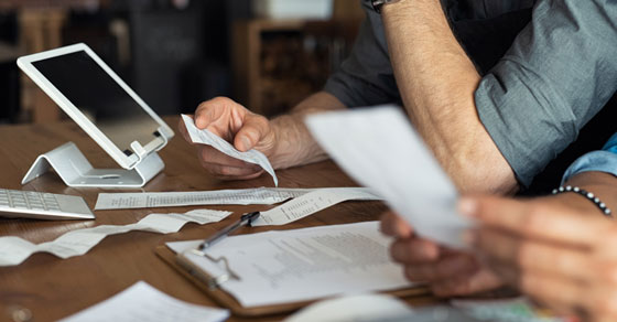 people sitting at a table with receipts and bills.