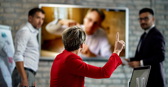 image of a meeting taking place and a woman raising her hand.