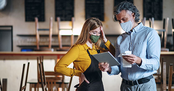 Individuals, in a restaurant, looking at an ipad