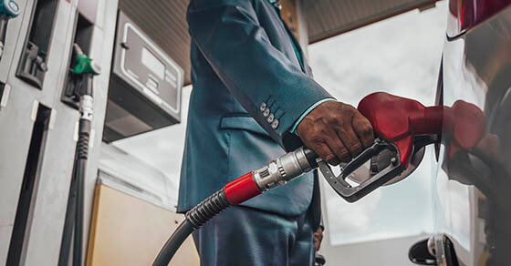 Young man refuelling his modern car at a petrol station