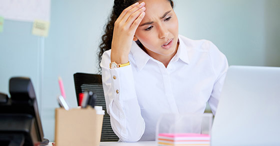 Shot Of An Attractive Young Businesswoman Sitting Alone In The Office And Feeling Stressed While Using Her Laptop