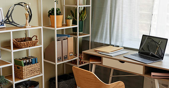 Background image of cozy home office workplace with wooden details and metal shelves with decor items, copy space