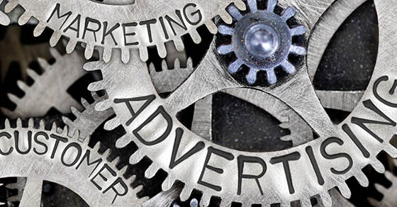 Macro photo of tooth wheel mechanism with ADVERTISING, SALES, PLAN, CREATIVITY, CUSTOMER, MARKETING concept words