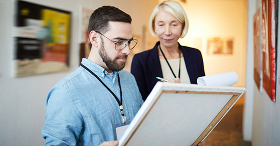 Two people looking at artwork.
