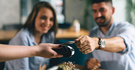 man making payment with smartphone in restaurant
