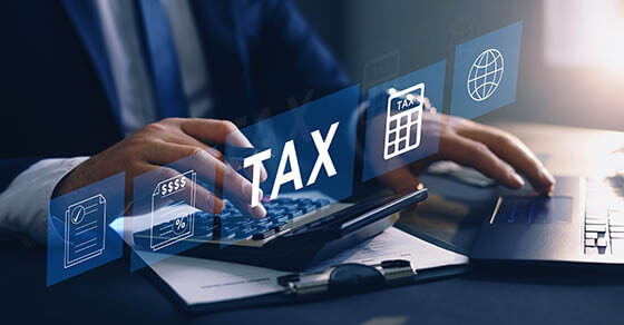 Businessman using the laptop to fill in the income tax online return form for payment.