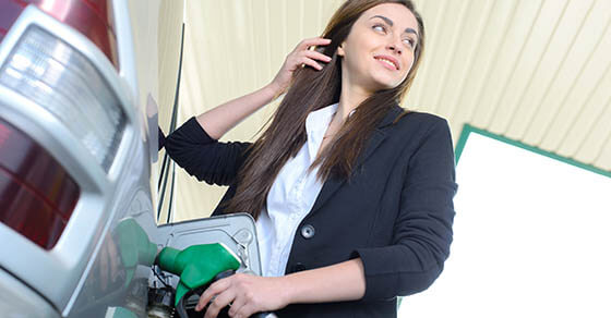 Business woman on filling station, while filling your car