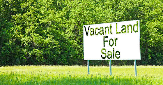 Advertising billboard immersed in a rural scene with Vacant Land for Sale written on it - image with copy space