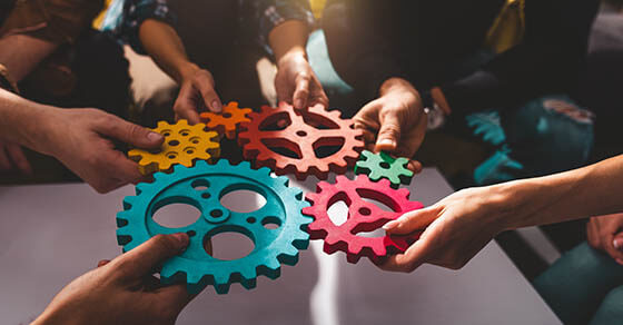 Teamwork of business people work together and combine pieces of gears