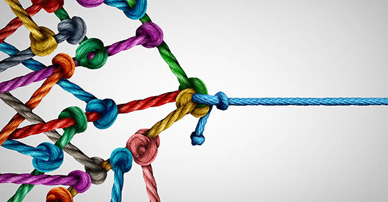 Against many business concept as one underdog single rope pulling in a tug of war with a large group of ropes tied together as a power and leader metaphor.