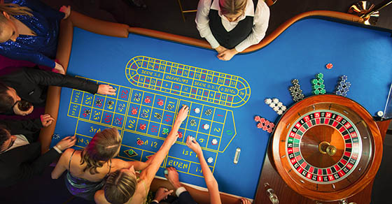 Top Down View: Luxurious Casino Male and Female Guests Putting Betting Chips on a Gambling Table, Trying to Predict the Outcome of a Roulette Game