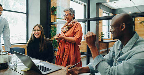 Diverse businesspeople smiling cheerfully during a meeting in a modern office. Group of successful businesspeople working as a team in a multicultural workplace.