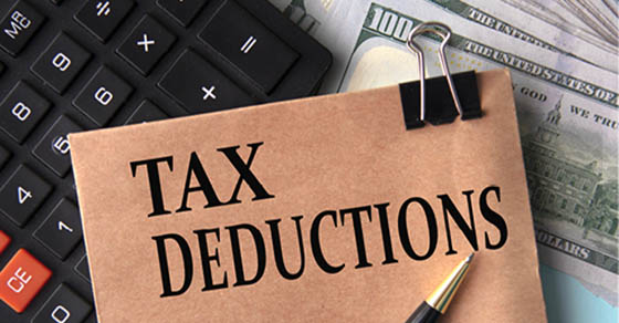 image of a calclulator, cash and an envelope that says "Tax Deduction"