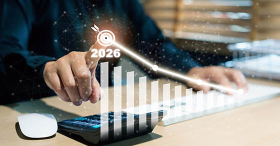 Asian businesswoman working on financial accounting, pointing at holographic target icon with year 2026 and business growth graph. Future success, financial planning, and business goal achievement.