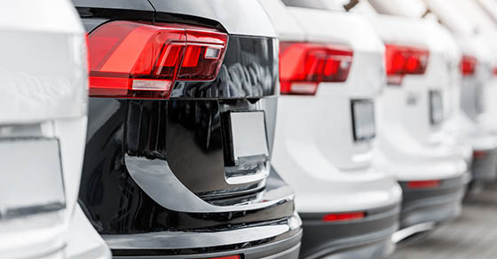 Back view many modern new SUV cars fleet stock at dealership parking lot. Automobile market production factory industry warehouse. Auto salvage buy and sell auction purchase seller platform