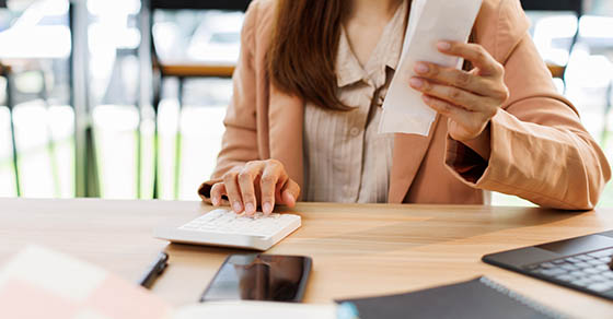 young woman hand checking list with bill for calculate accounting expense credit card payment on due deadline, trying to find money to pay debt on table. Business financial concept,