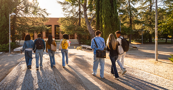 image of young adults with bookbags walking