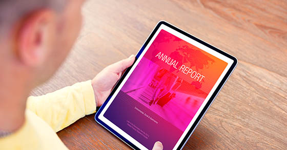 Man reading electronic company's annual report on digital tablet